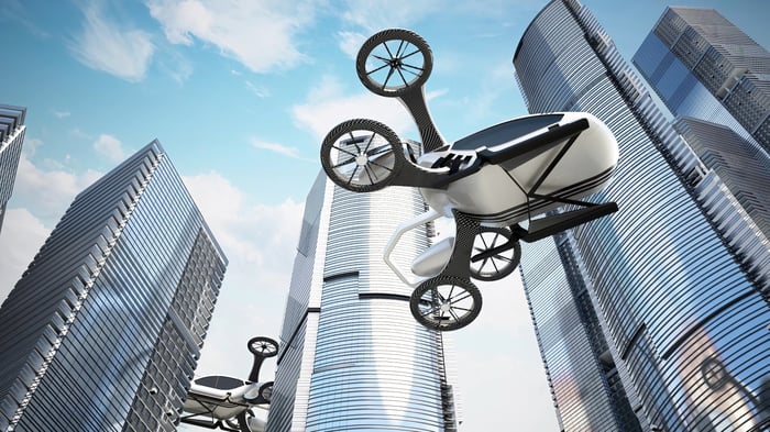 Flying taxis cross a city.