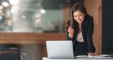 An excited businessperson looking at their computer.