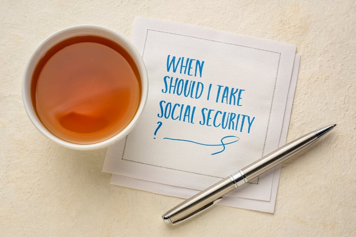 A napkin with "when should I take Social Security?" on it next to a cup of tea.