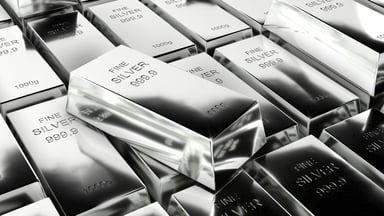 A high-angle view of multiple silver bullion bars arranged in a clean, repeating grid.