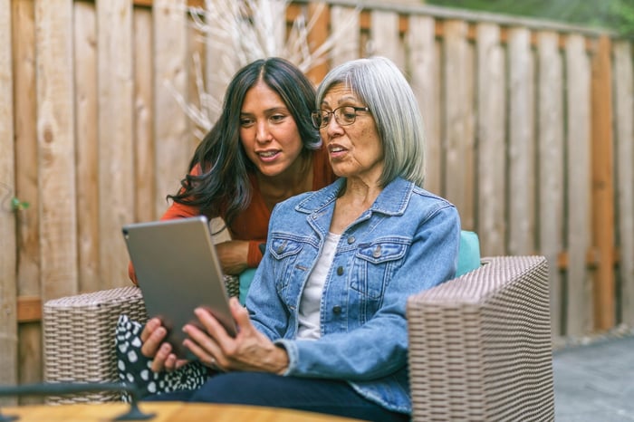 Two people looking at tablet together.