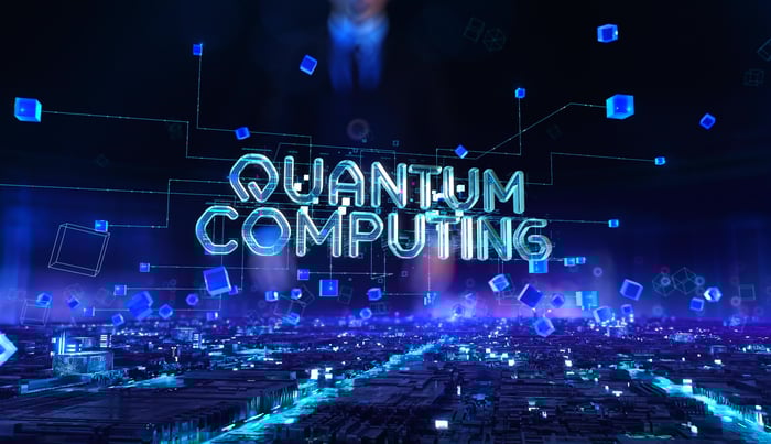 "Quantum Computing" text in lights with digital images in the background.