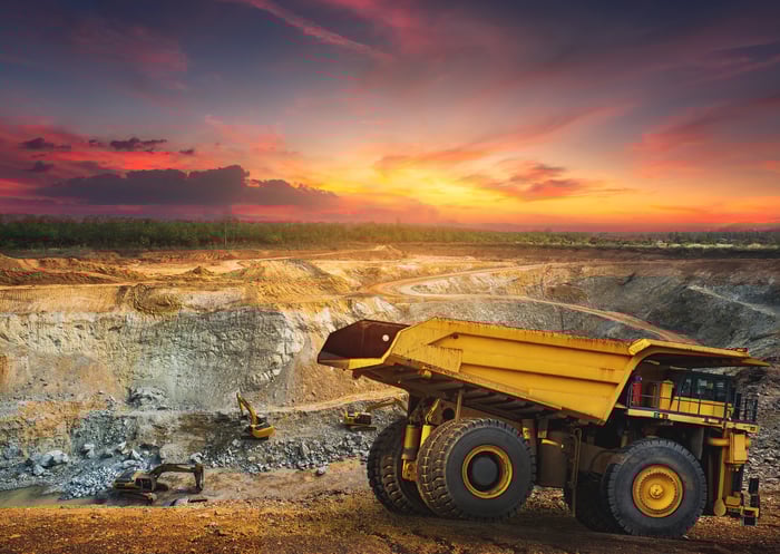 A dump truck is parked near a rare earth mine. 