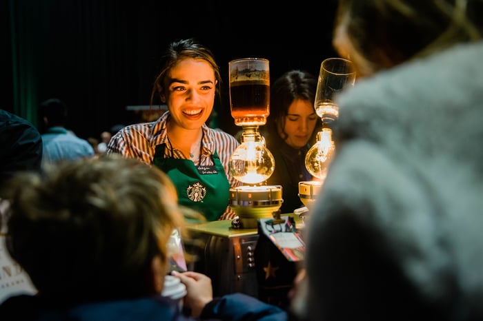 Starbucks barista serving coffee.