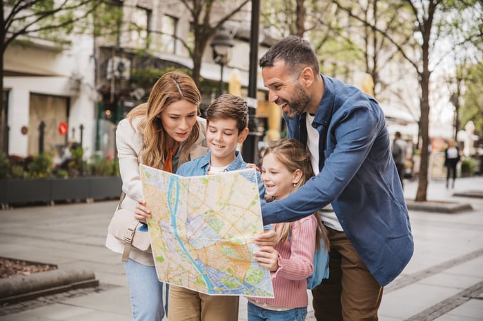 A family on a street looking at a map. 