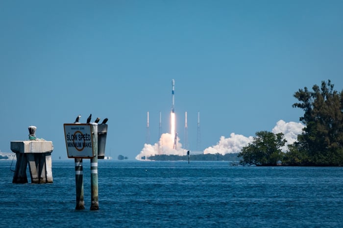 A rocket launch seen from across a body of water.