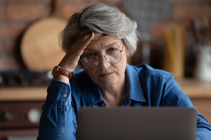 Worried person looking at laptop.