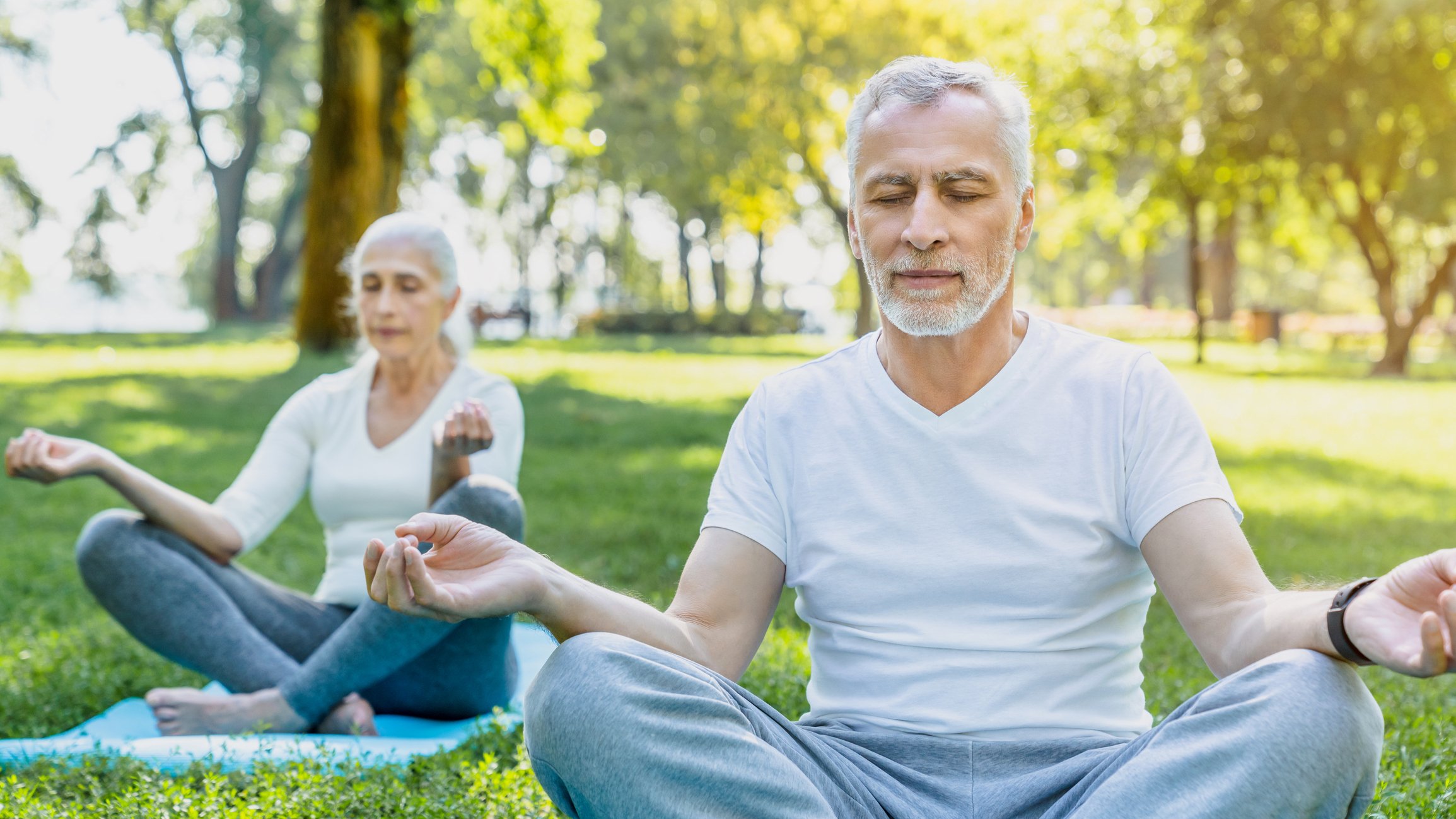 Getty - two people doing yoga or meditating outside health exercise