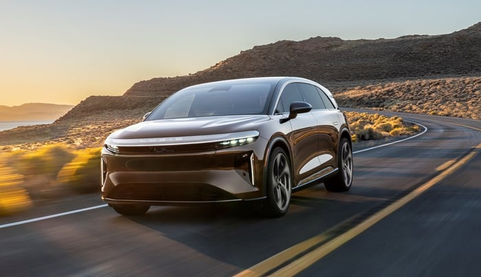 A Lucid Gravity, a sleek electric luxury SUV, on a coastal road. 