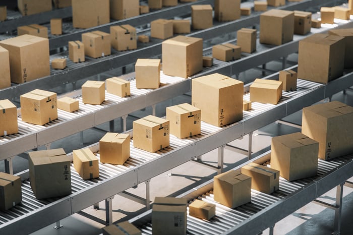 Boxes line a conveyor belt. 