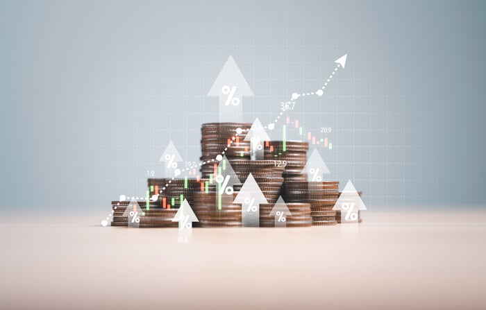 A stack of coins with arrows and a chart superimposed onto them. 