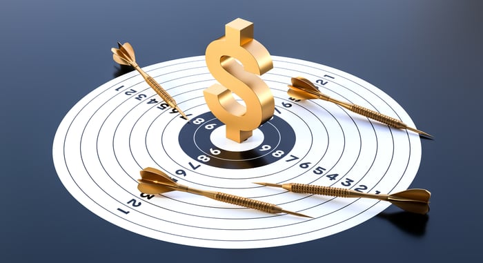 A dartboard with a gold dollar sign in the middle. 