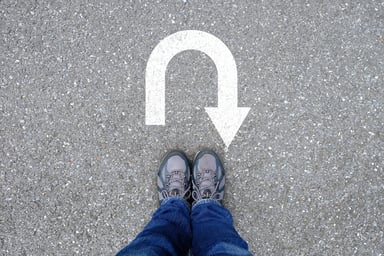 24_03_25 A person standing with a u turn sign on the ground in front of them _GettyImages-1055924890-1200x800-5b2df79
