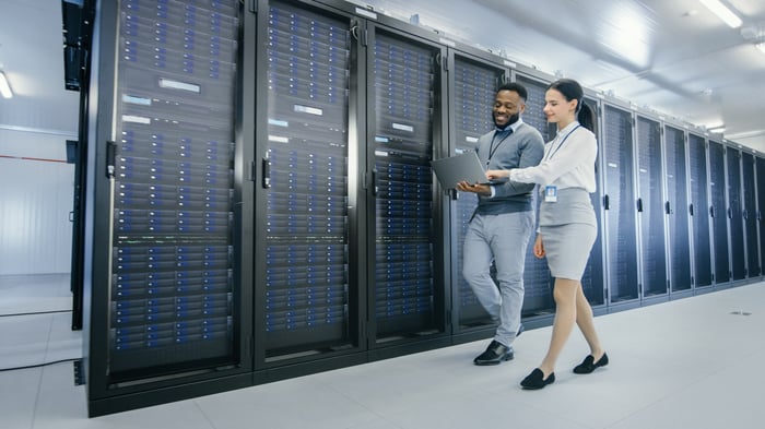 Two technicians walking through a modern data center.