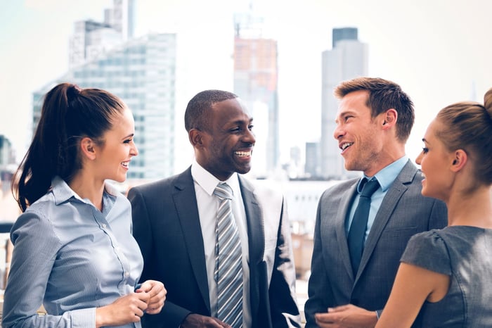 A group of business people talking outside.