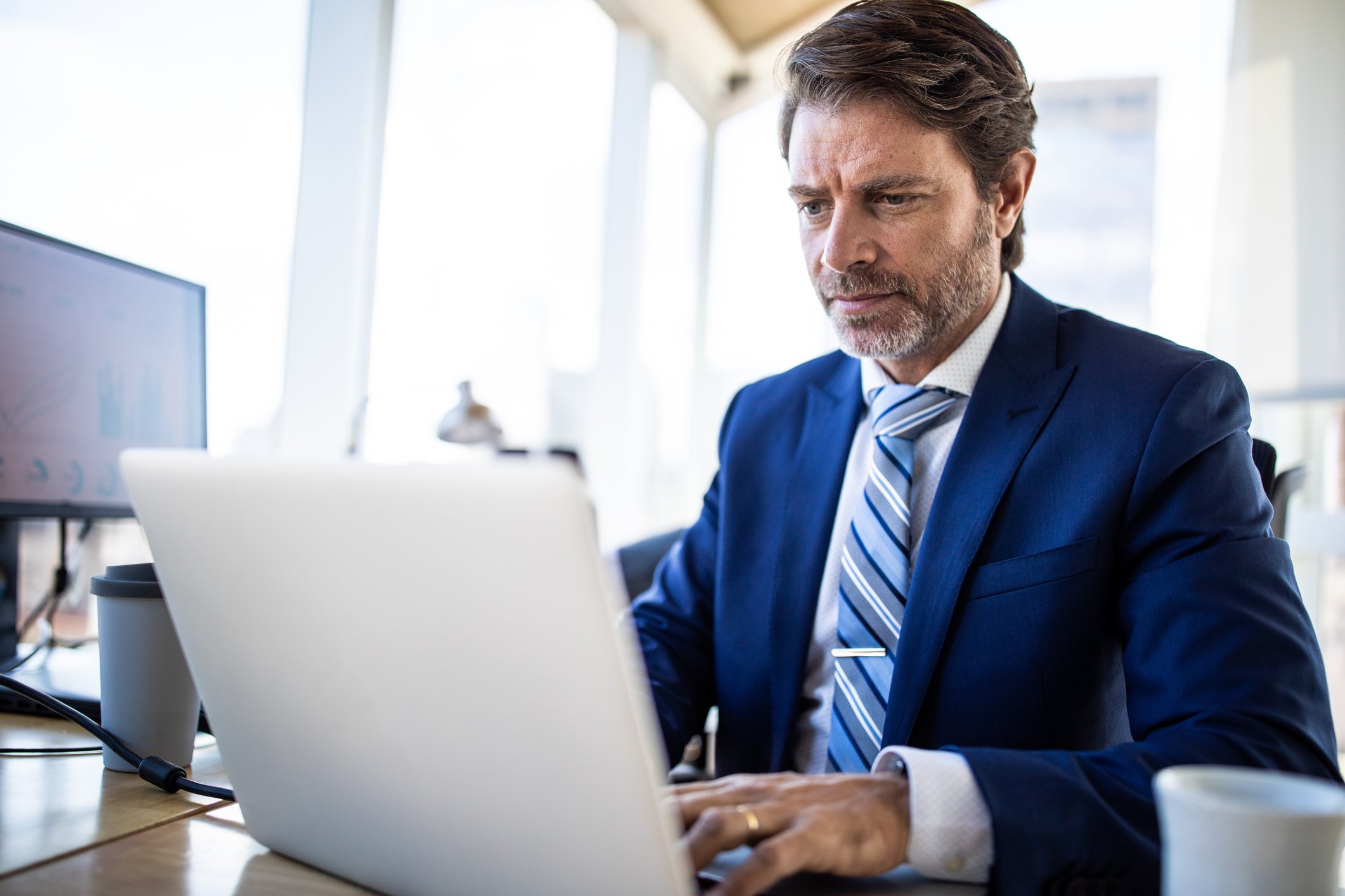 Man middle aged business suit serious laptop GettyImages-1207304964