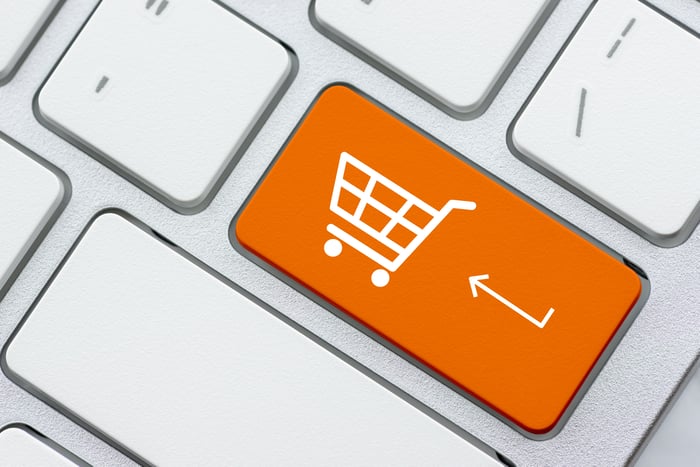 an orange computer key with a shopping cart