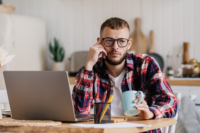 A person with a serious expression at a laptop.