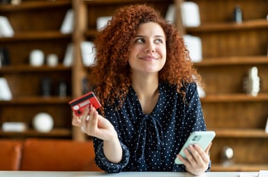 Person holding a phone and a credit card
