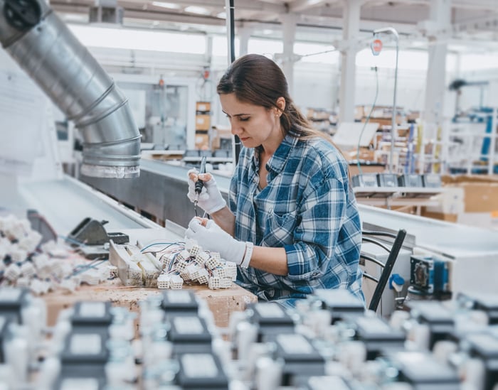 A factory working is on an assembly line. 