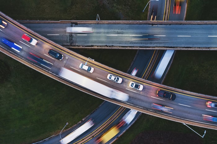 Cars zoom off of a high way. 