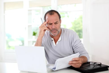 man looking at paper document concentrating confused