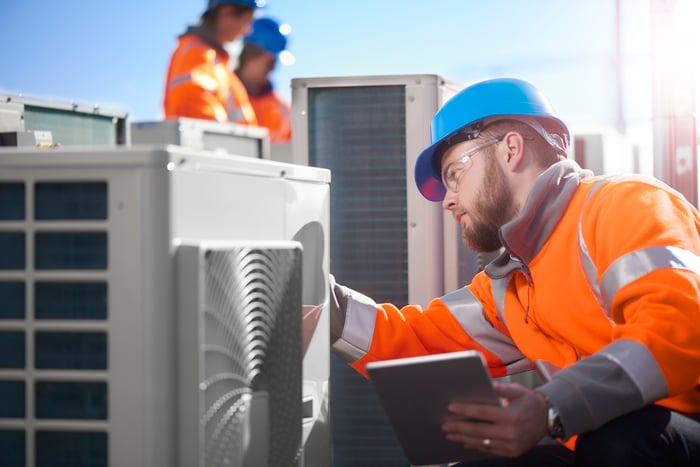 An HVAC technician works on a cooling system.