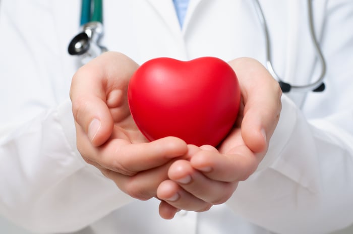Doctor cradling a heart-shaped soft toy.