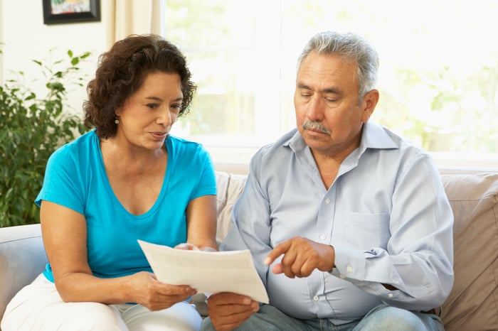 Serious couple looking at document together.