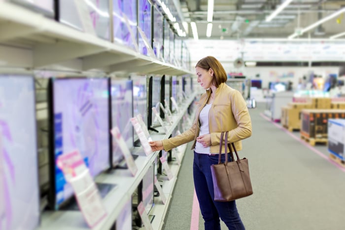 A person is shopping in a retail electronics store. 