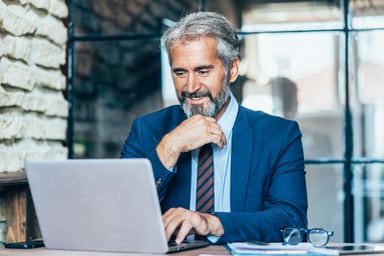 Man older business suit laptop GettyImages-1193688718
