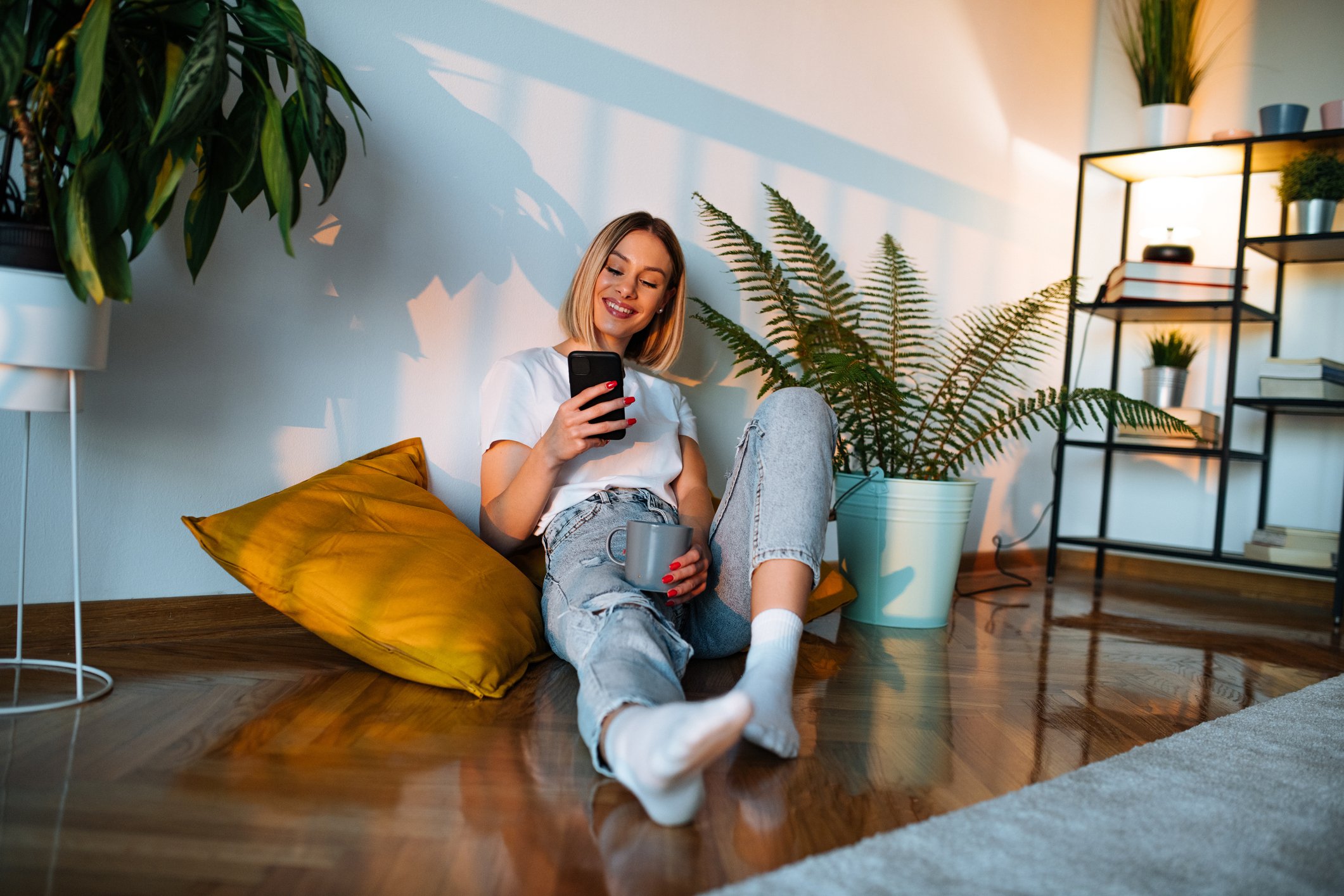 person on their phone in apartment sitting on the floor