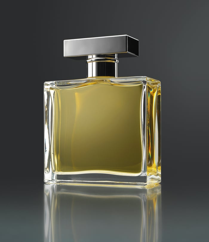 A glass perfume bottle sits on a surface.