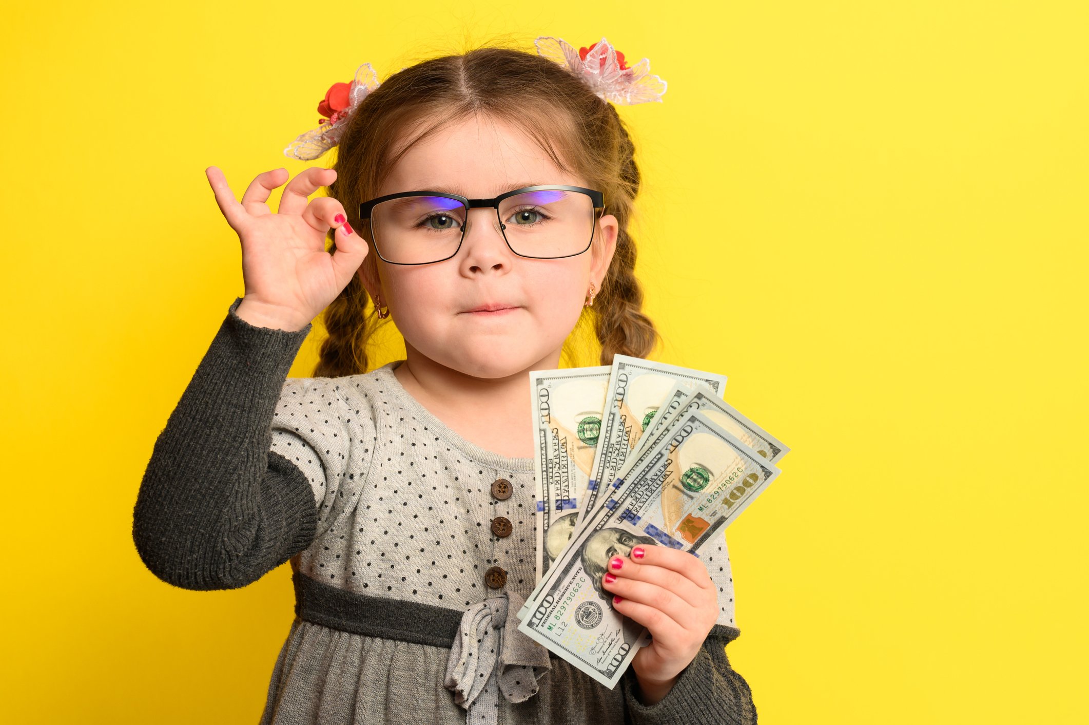 Getty - smart kids children with glasses cash dollars savvy moves money