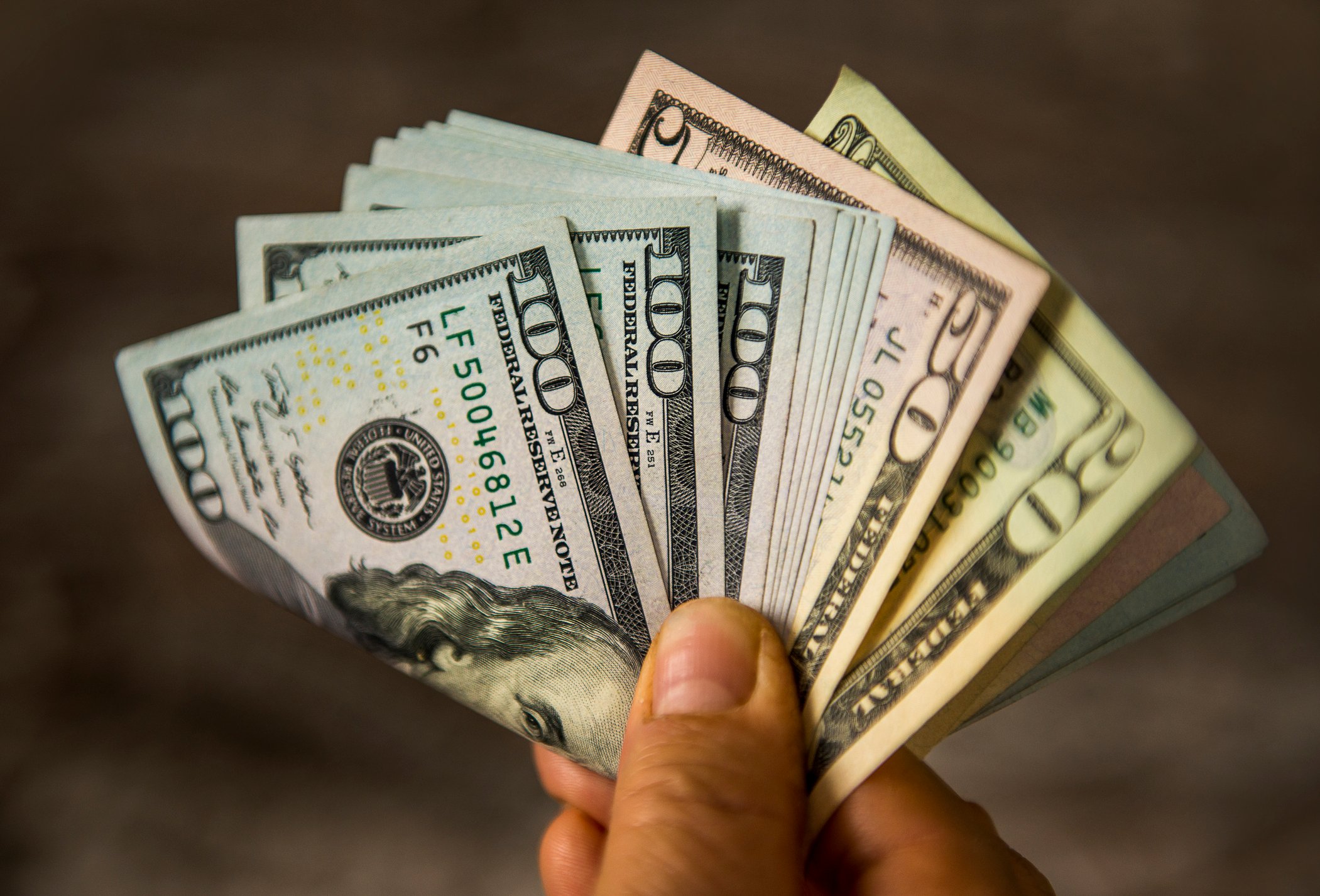 dividend cash holding money rich wealthy hundreds franklins hand
