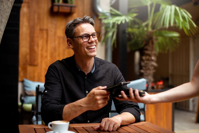 Someone using tap to pay with their smartphone.