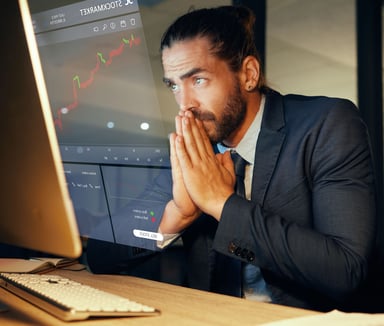 Concerned investor looking at a stock chart on a computer.