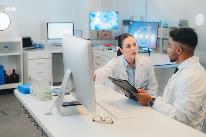 Two doctors discuss testing results in a modern medical office.