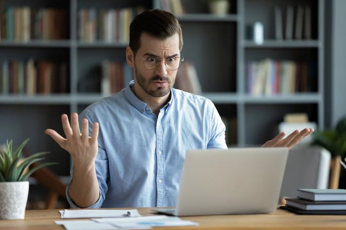 A confused investor sitting in front of their computer.