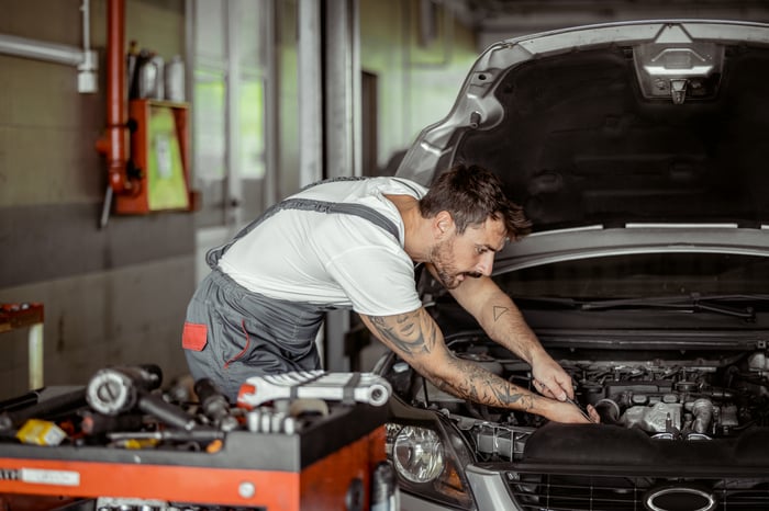 A person works on a vehicle in an auto repair shop