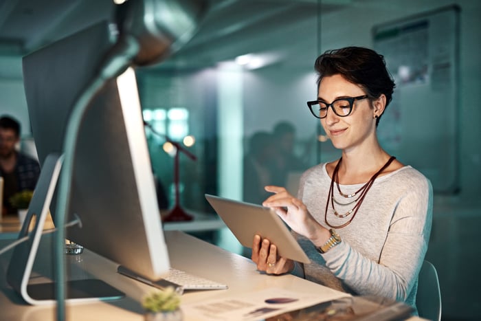 An investor looks at something on a tablet in an office. 