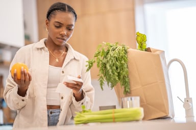 Person holding an organce and looking at a receipt