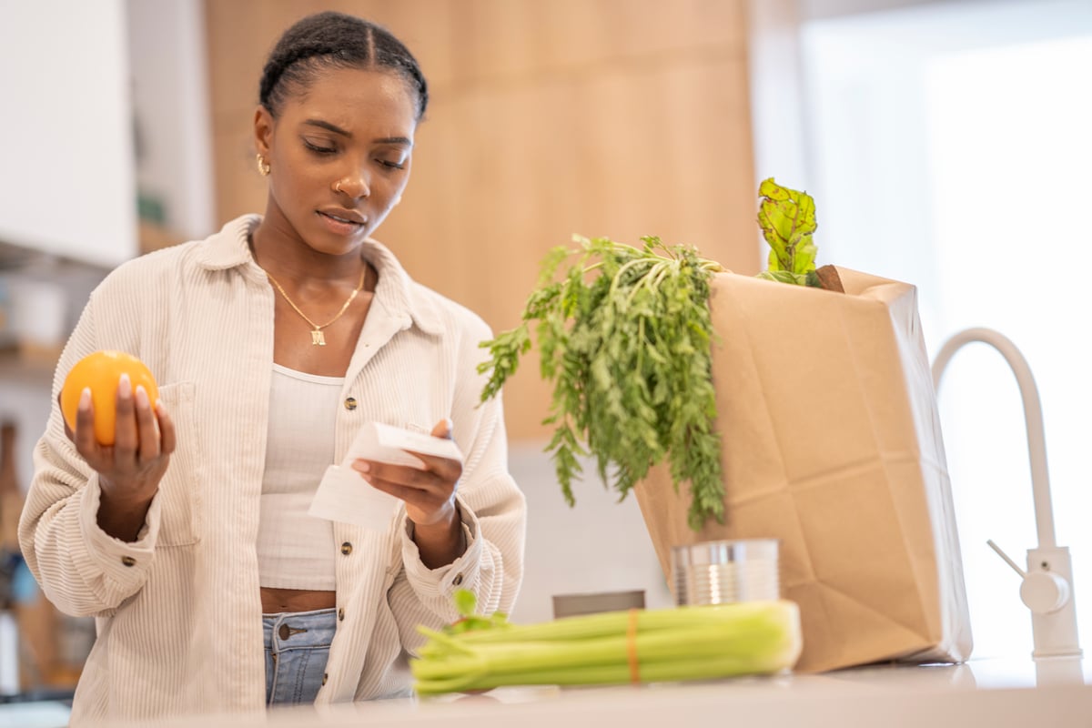 Person holding an organce and looking at a receipt