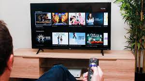 A person with a remote going through a TV streaming application. 