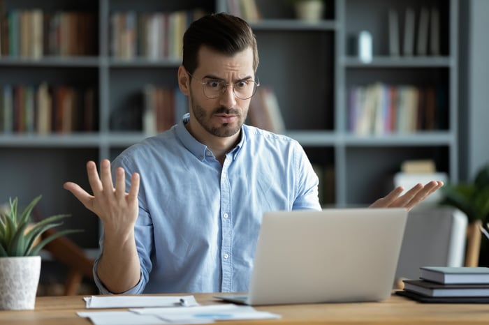 Person looking at a computer screen in disbelief.