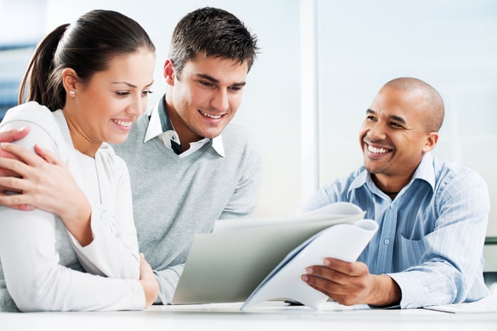 Professionals discussing contents of a paper with each other.