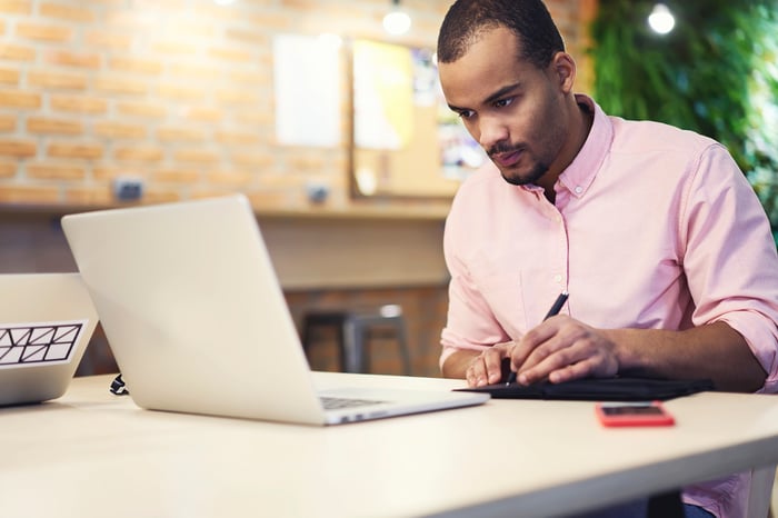 An investor works on a laptop.