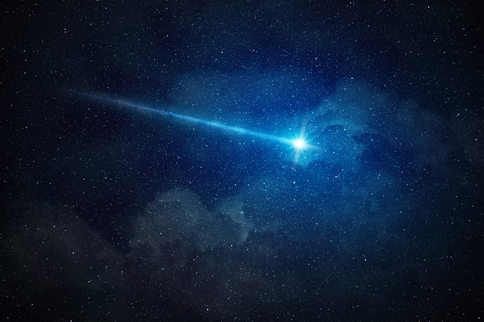 Falling star in a black sky.