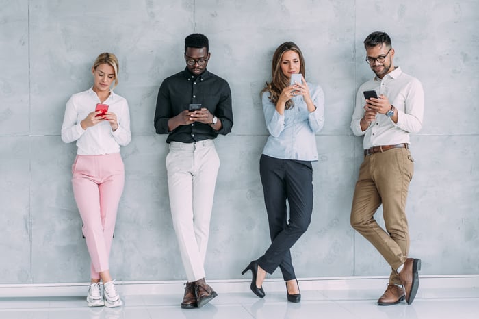 Four people looking at phones.