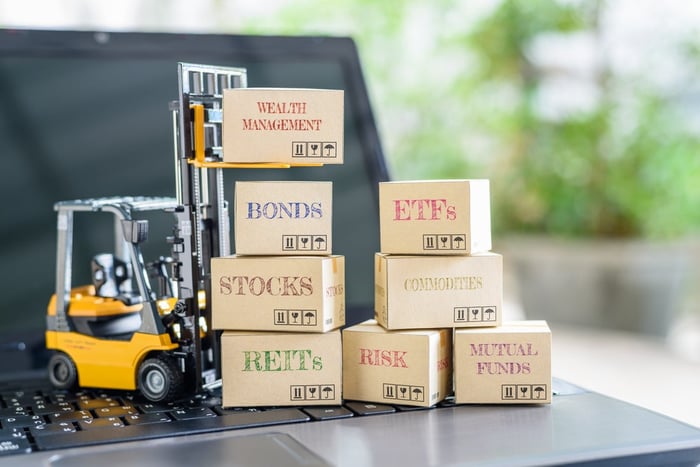 Toy forklift, lifting boxes with investment-related terms stamped on them. 